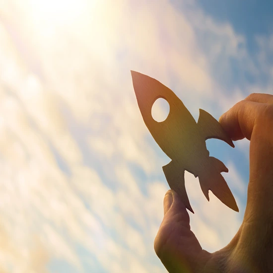 wooden cut out of rocket flying through the sky.